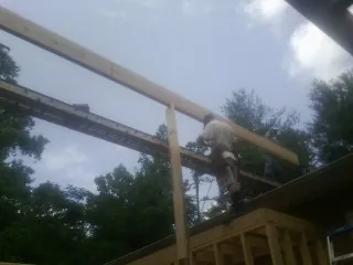 Carpenter setting a ridge beam over a new addition frame — Ice Dam Removal by Roofing Brothers in Vero Beach