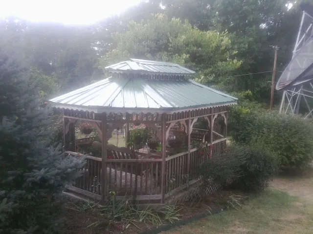 Green metal roof on a backyard gazebo surrounded by garden beds in Vero Beach